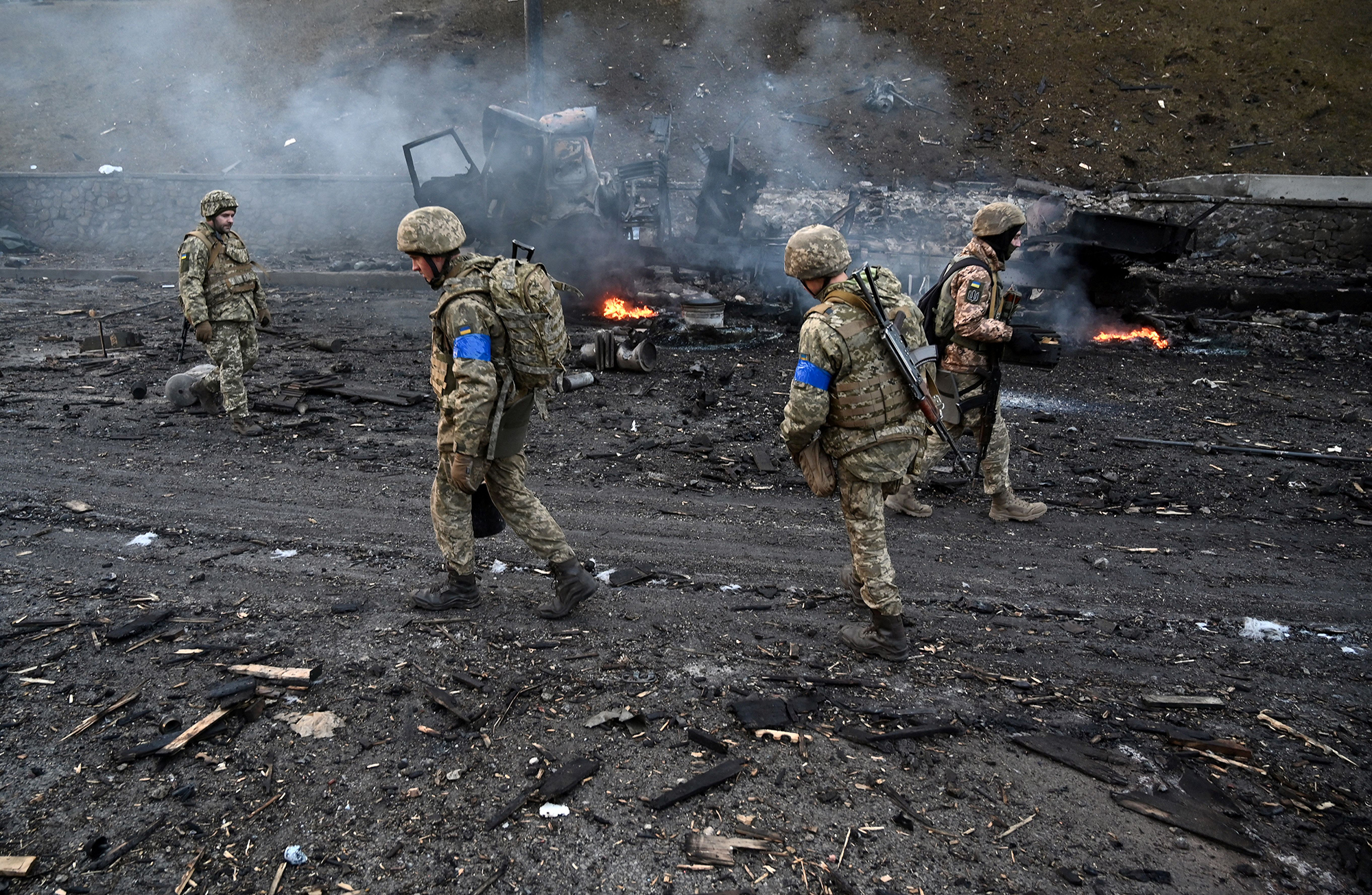 Ukrainian service members collect unexploded shells after fighting with advancing Russian troops in Kyiv, early Saturday morning on February 26.