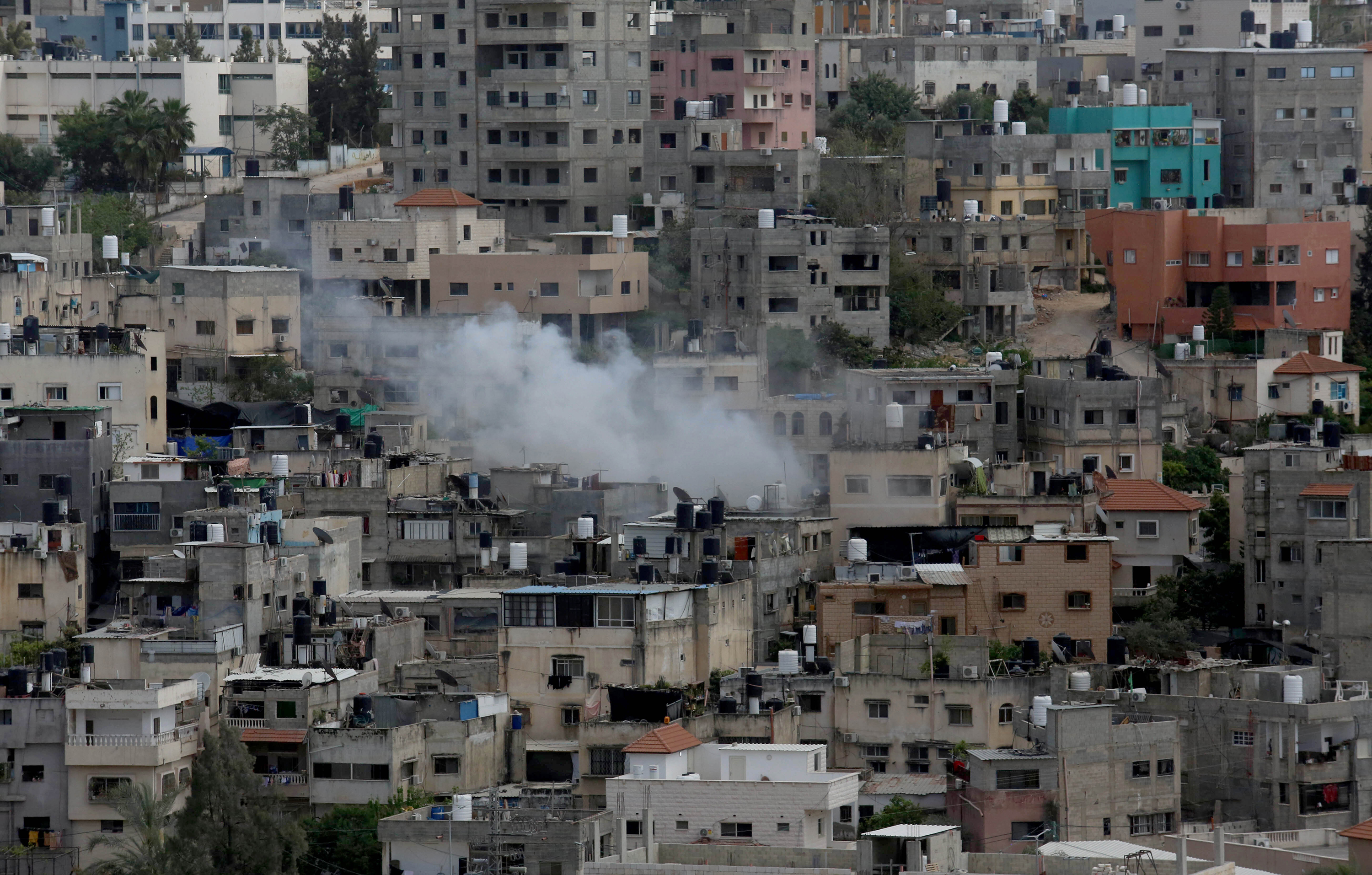 Smoke rises from a building in Tulkarm, West Bank on April 19.