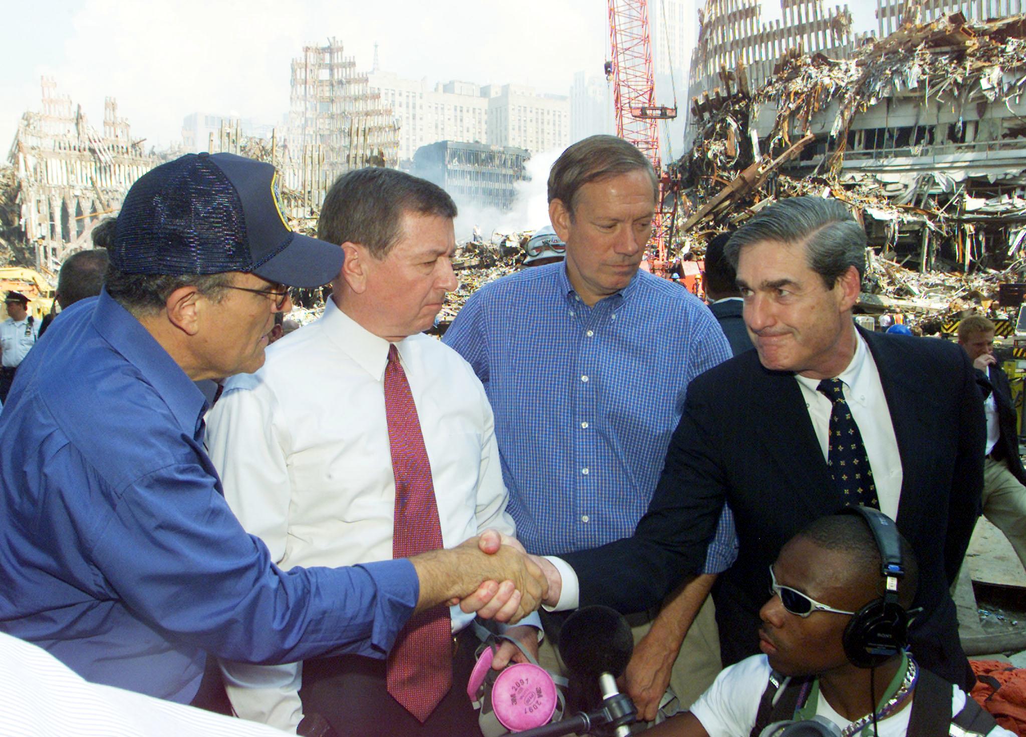 FBI Director Robert Mueller (R) shakes hands with New York Mayor Rudolph Giuliani (L) at the World Trade Disaster site in New York 21 September 2001.