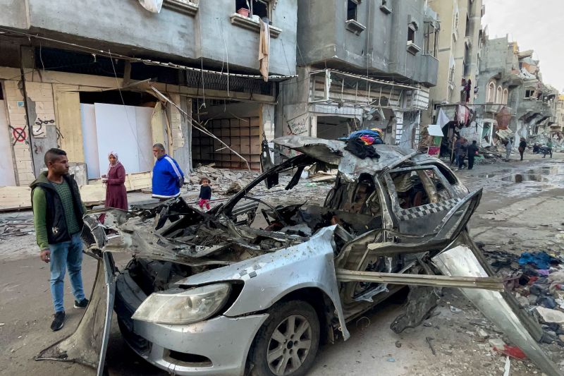 People look at the car in which three sons of Hamas leader Ismail Haniyeh were reportedly killed in an Israeli air strike near Al Shati, northwest of Gaza City, on April 10. 