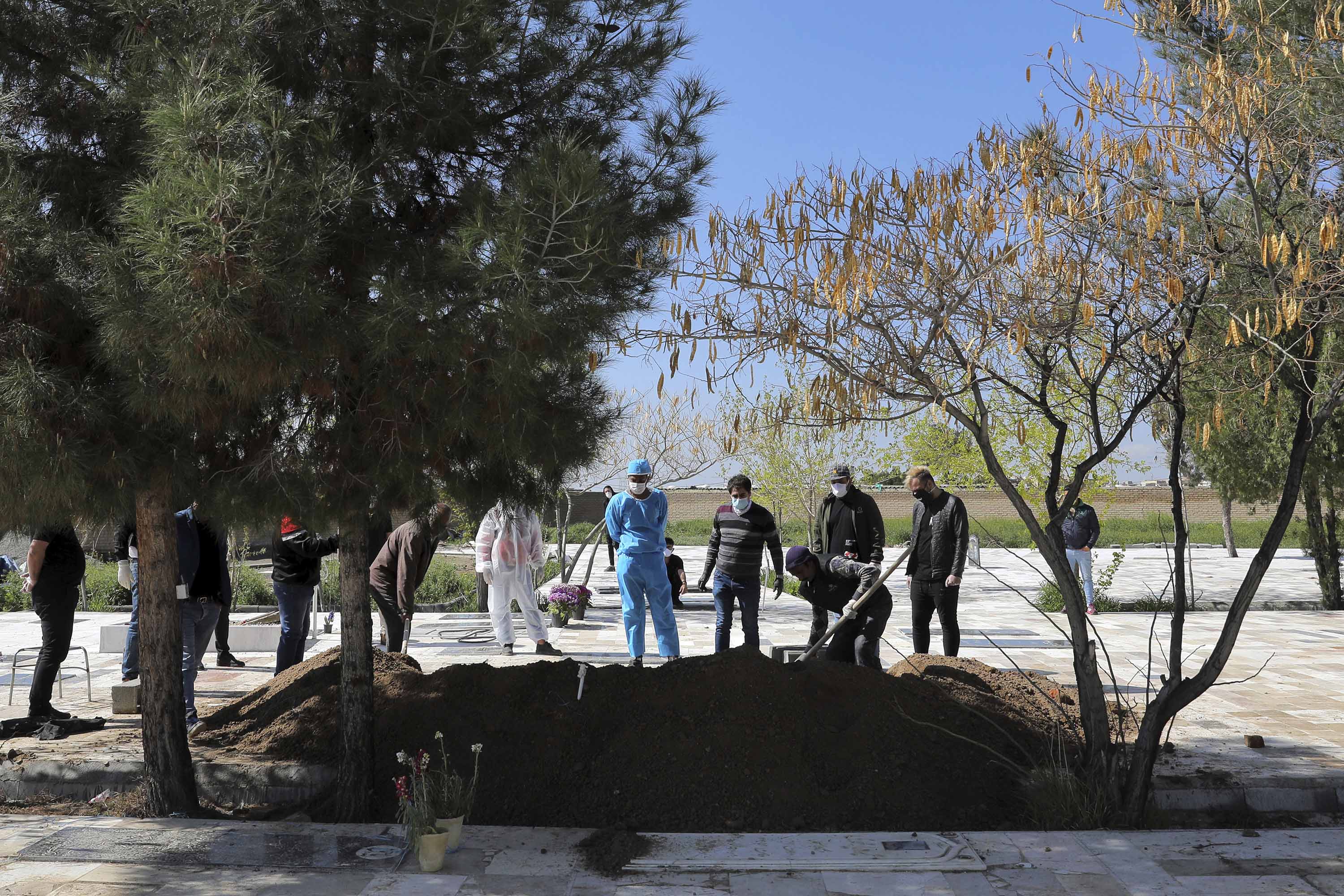 People attend a funeral for a coronavirus victim at a cemetery outside Tehran, Iran, on March 30.