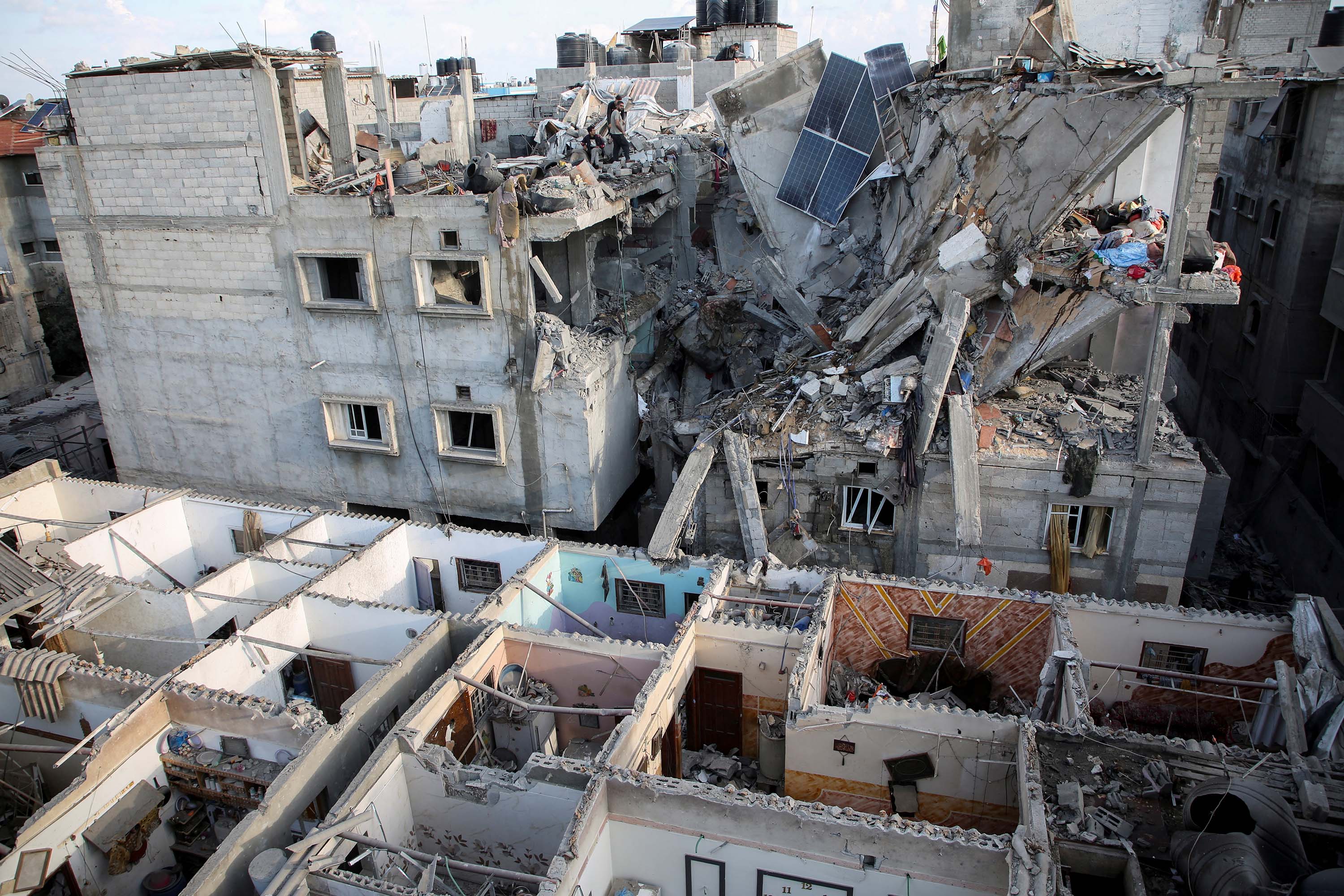 People inspect the site of an Israeli strike on a house in Rafah on Tuesday, May 7.