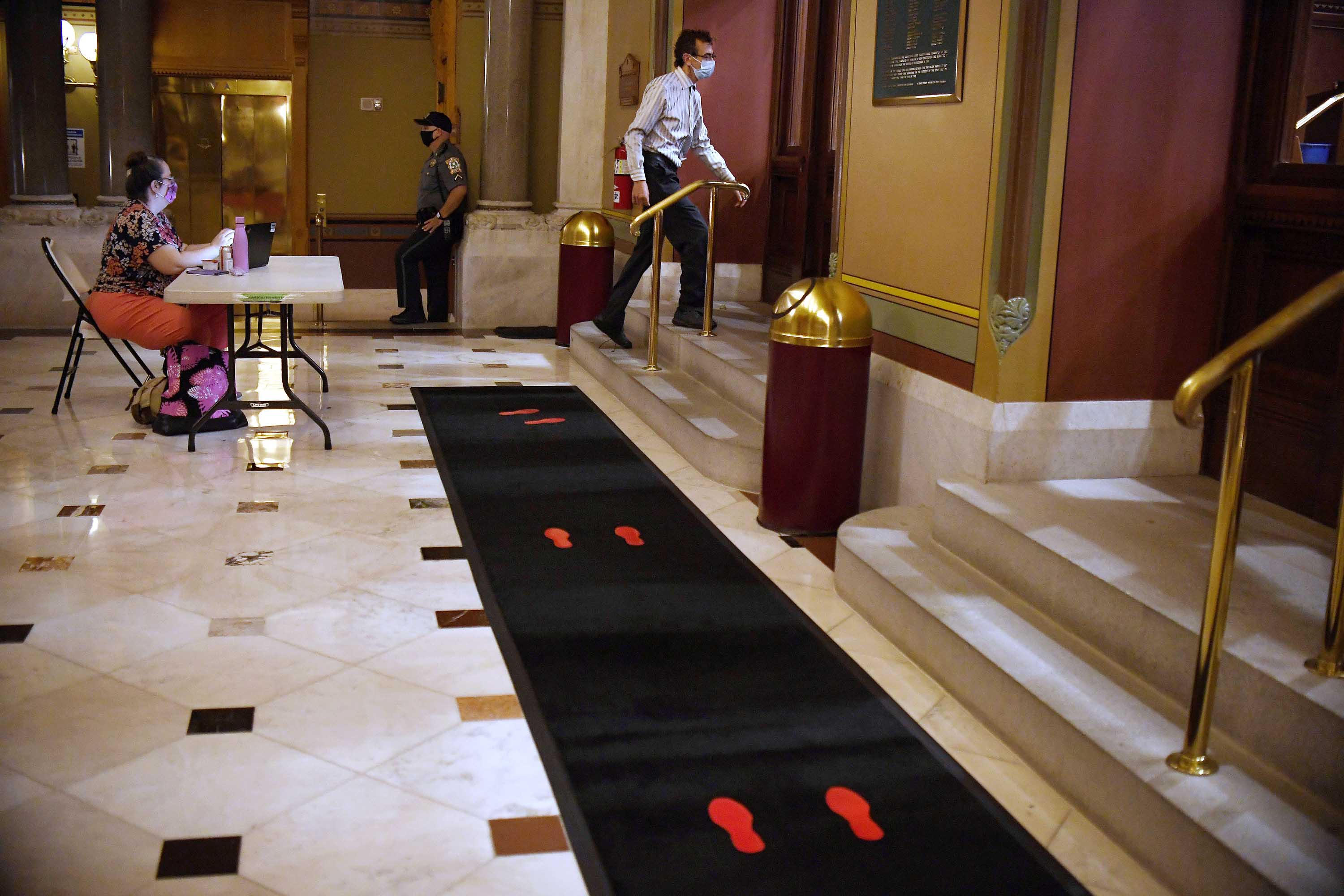 A floor mat indicates social distancing guidelines as legislative staff members enter the House at the Connecticut State Capitol in Hartford, on July 23.