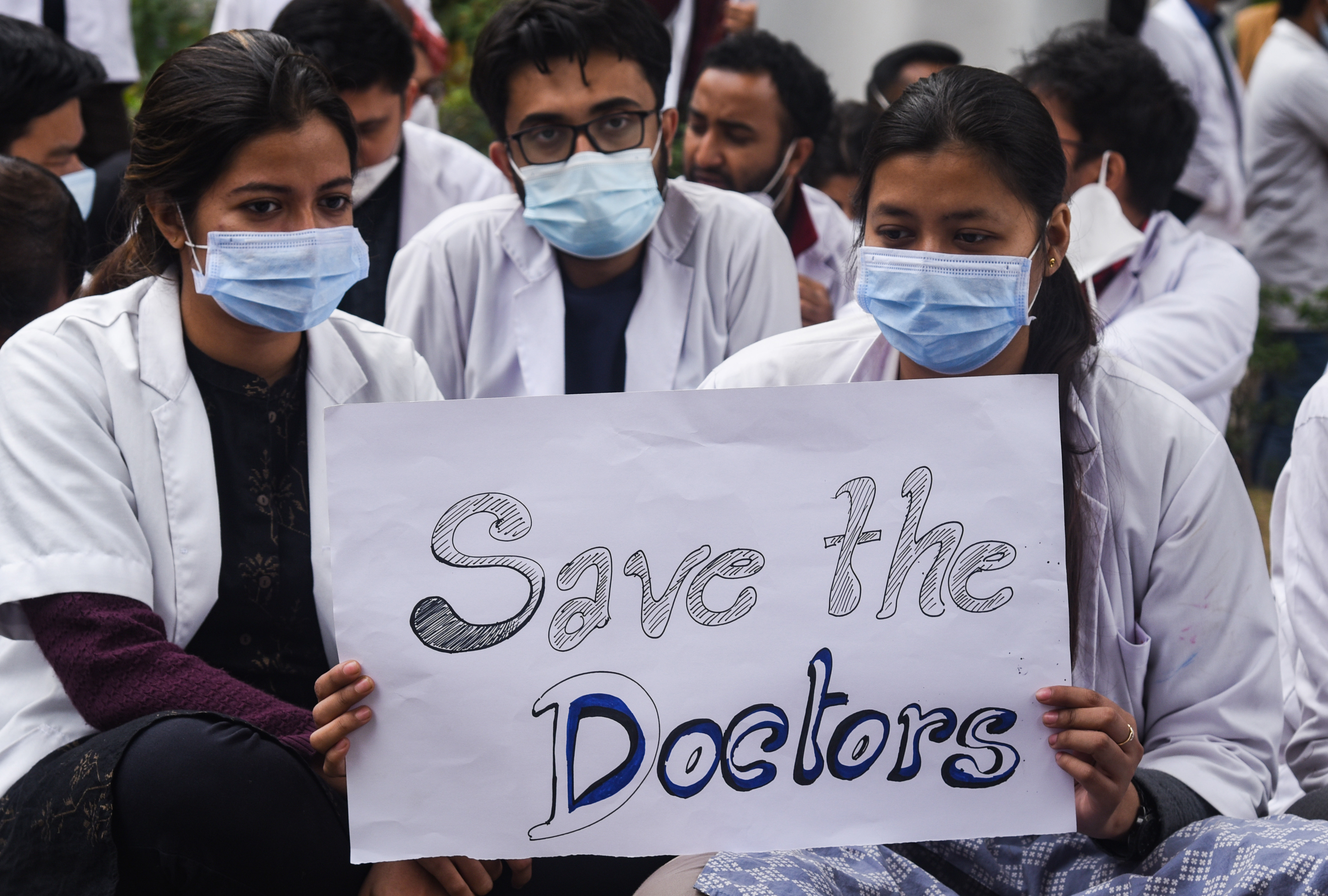 Junior doctors stage a protest to condemn the police action on a peaceful protest of resident doctors in Delhi who were agitating over delay in NEET counselling, at Gauhati Medical College Hospital (GMCH) in Guwahati, Assam, India on Wednesday, December 29, 2021. 