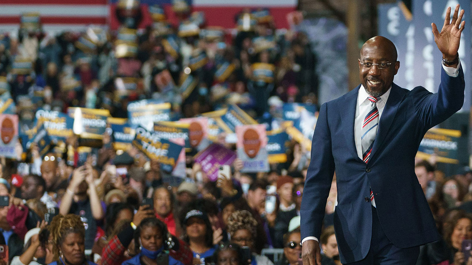 U.S. Sen. Raphael Warnock takes the stage at a campaign rally in Atlanta on Thursday.