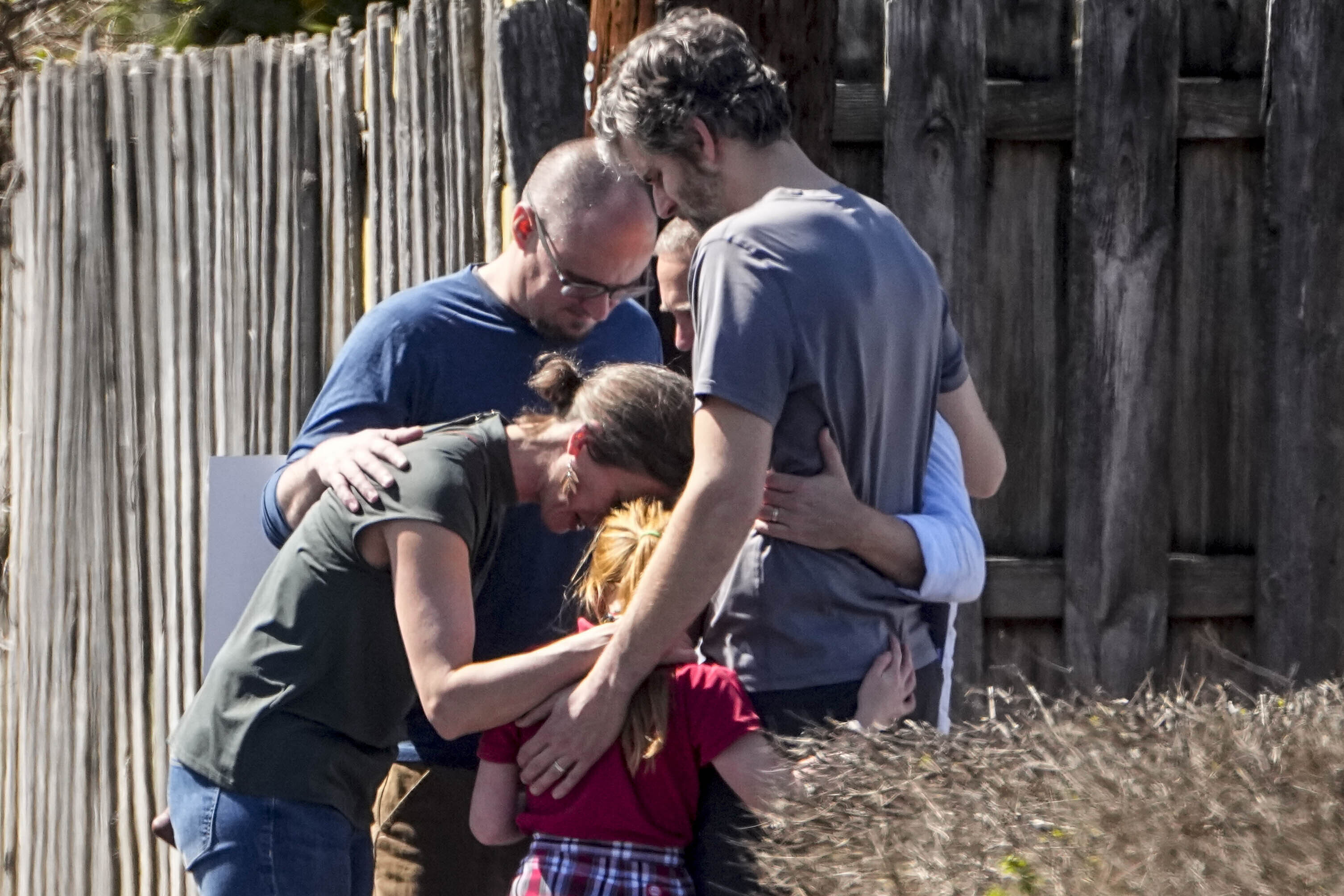 A group prays with a child outside the reunification center at the Woodmont Baptist church after a school shooting on Monday, in Nashville, Tennessee.