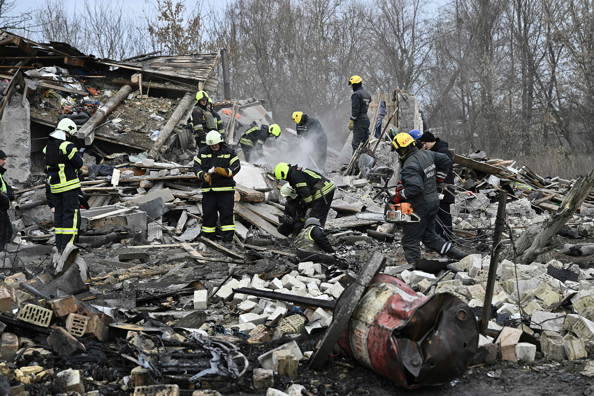 Rescuers clear debris from homes destroyed by a missile attack on the outskirts of Kyiv, Ukraine, on December 29.