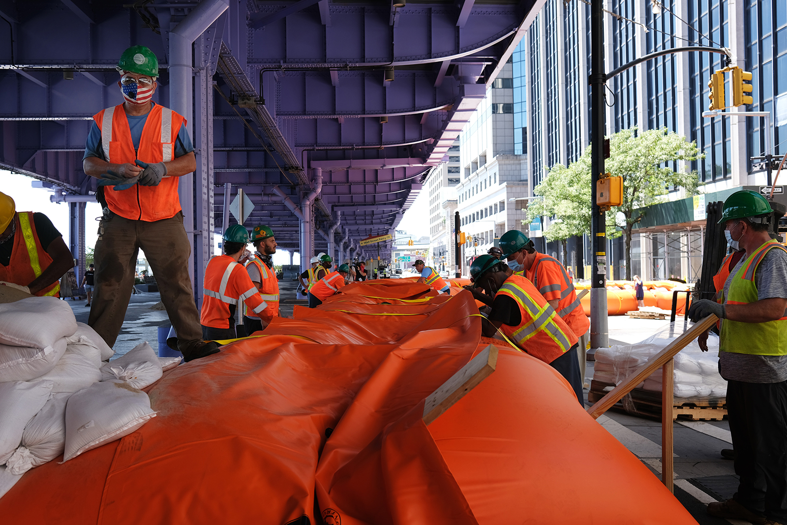 Workers erect temporary flood barriers in the South Street Seaport neighborhood in preparation for potential flooding and a storm surge from Tropical Storm Isaias on August 3 in New York.