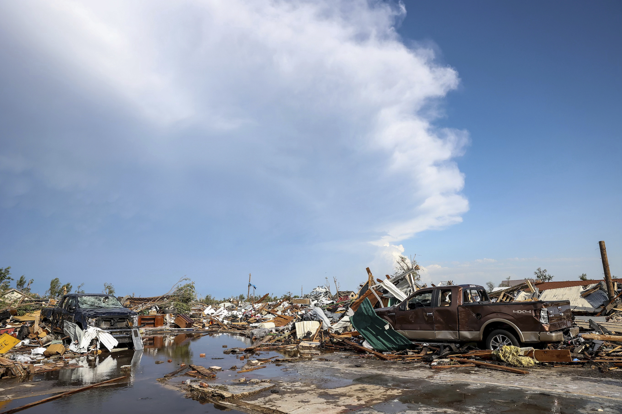 Damaged pickup trucks sit among debris after a tornado passed through a residential area in Perryton, Texas, on Thursday.