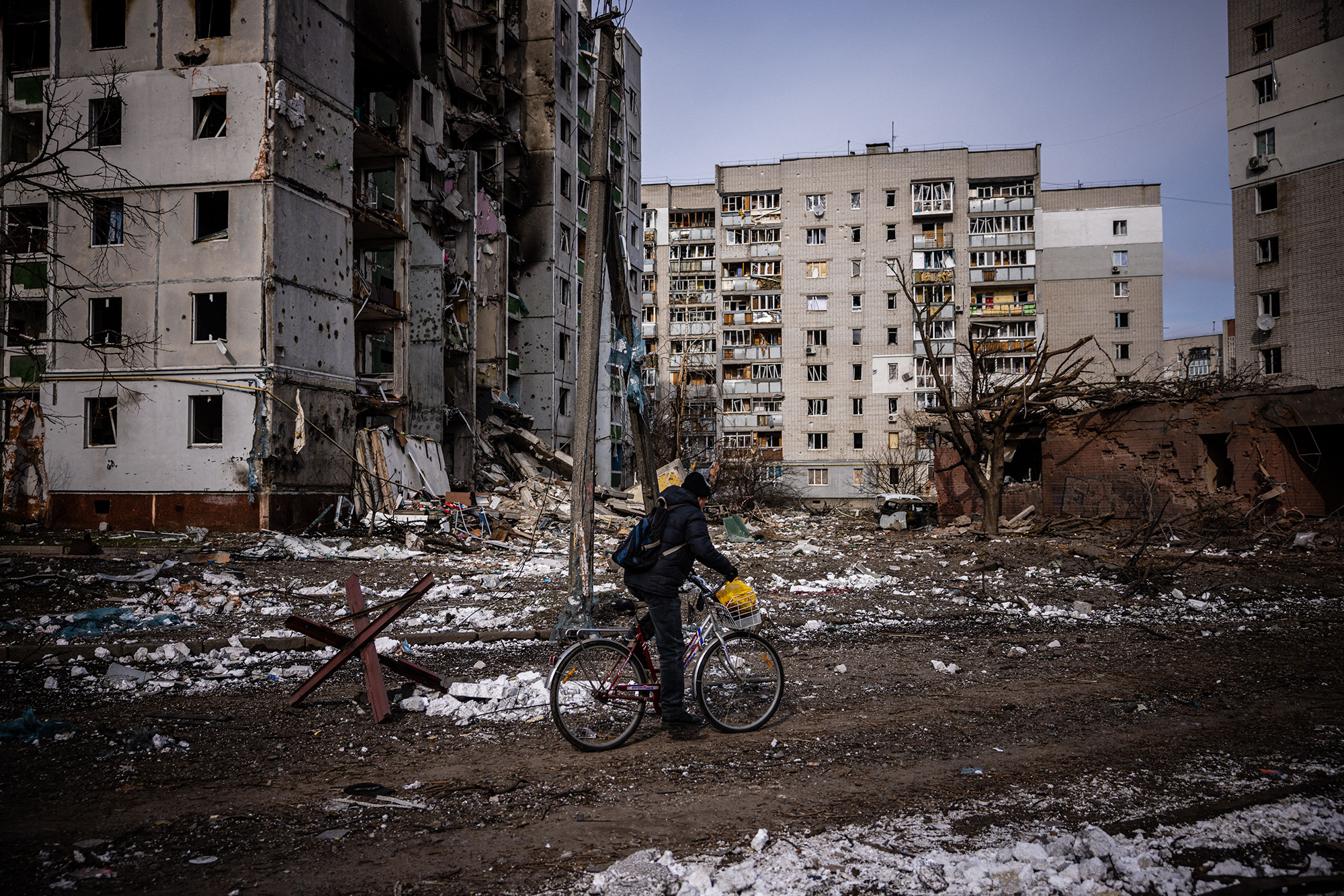 A man rides his bicycle near damaged residential buildings in Chernihiv, Ukraine on March 4. 