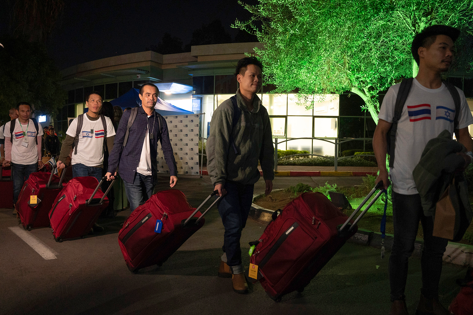 Thai nationals walk to a bus as they leave the Shamir Hospital in Ramle, Israel, on Wednesday, November 29, on their way back to Thailand.