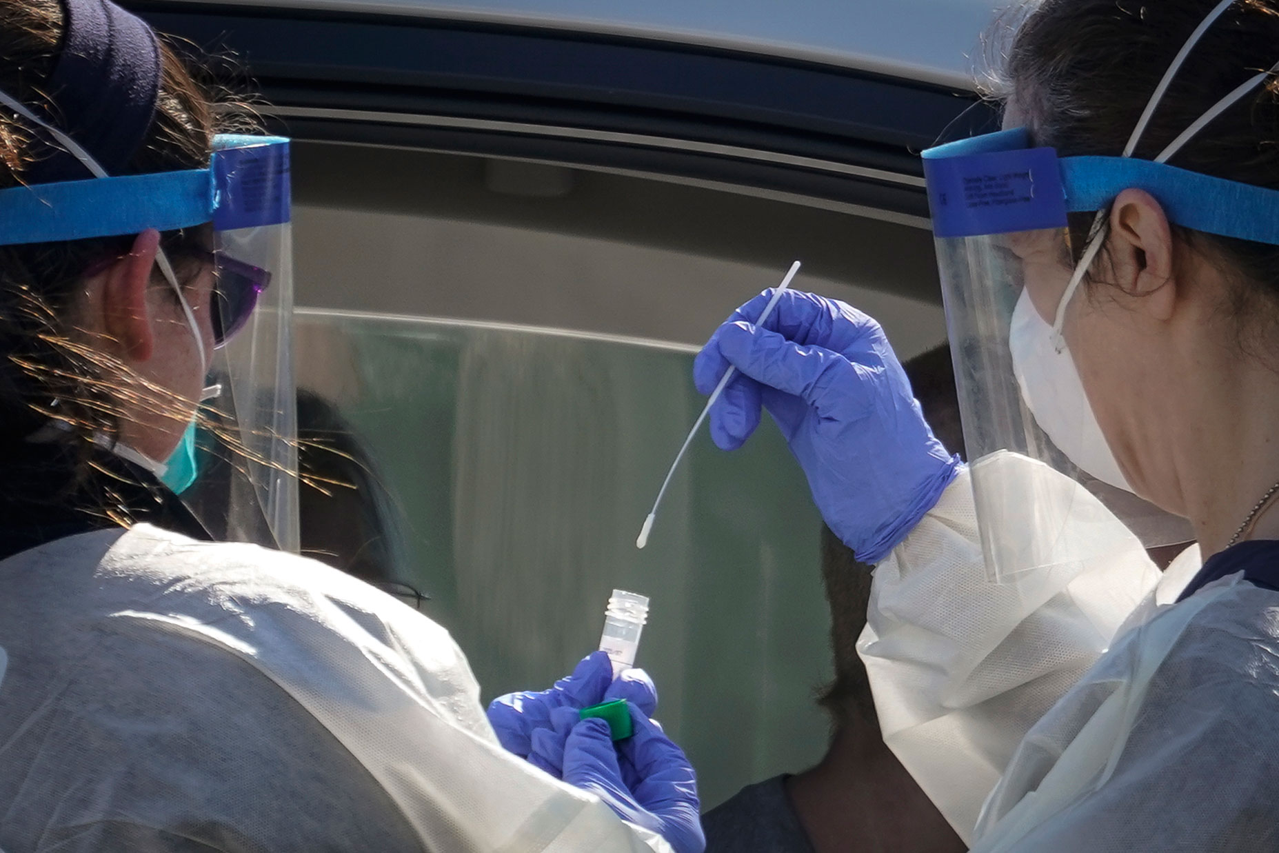 Medical professionals from Children's National Hospital administer a coronavirus test at a drive-thru testing site at Trinity University on April 2 in Washington, DC.