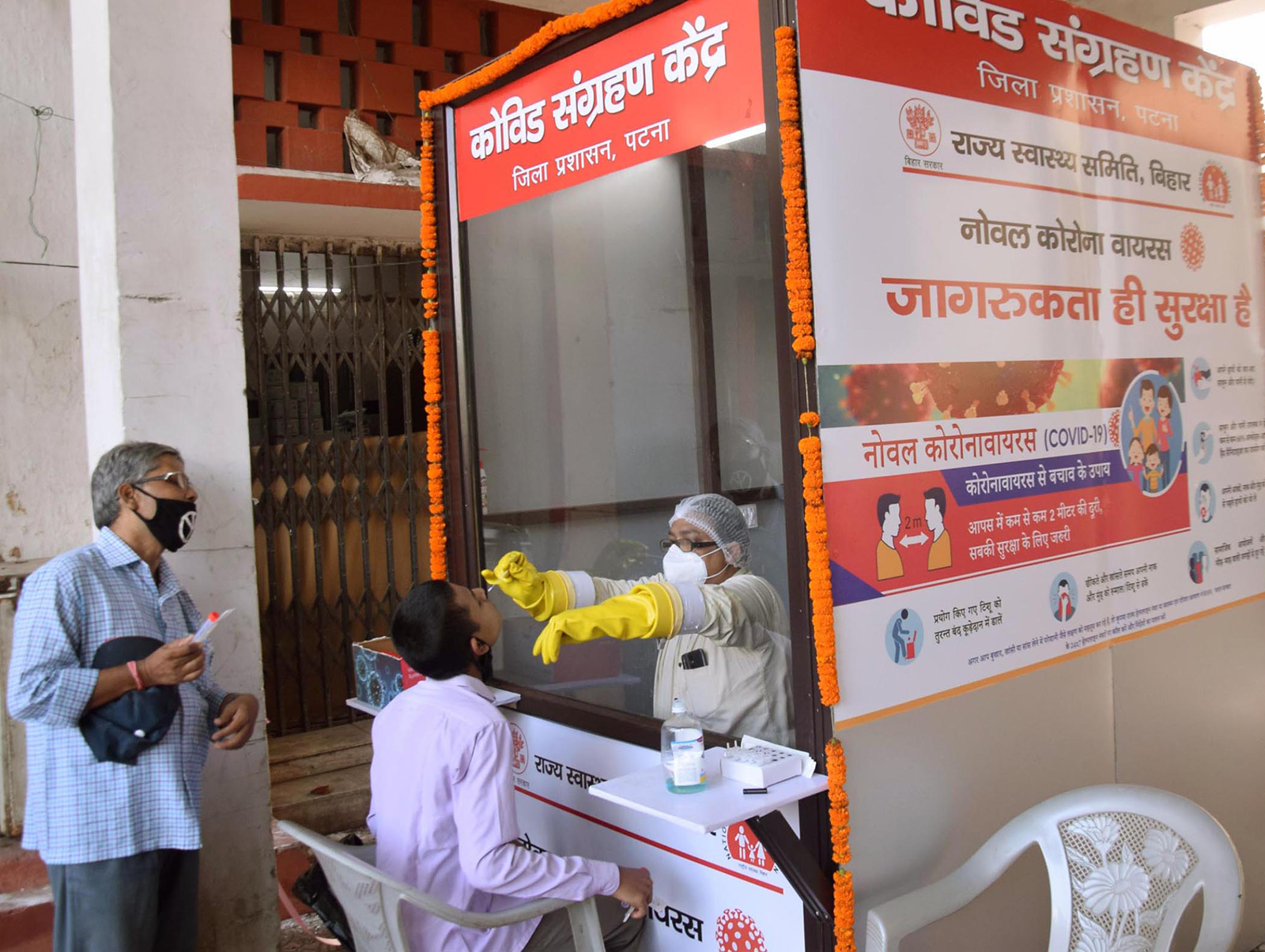 A medic collects a sample from a patient for Covid-19 at Gardiner Hospital in Patna, India on July 15.