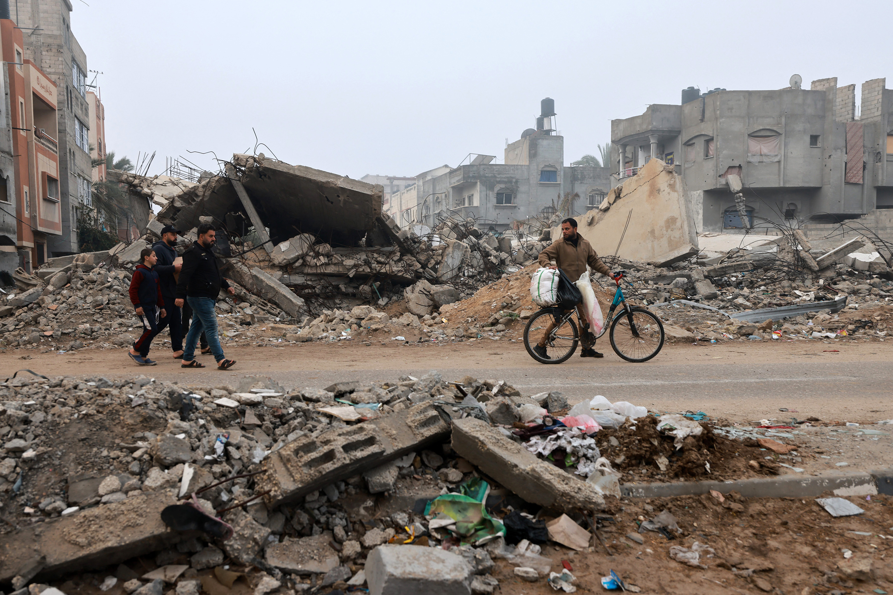 Men walk along a street ravaged by Israeli bombing in Rafah, Gaza, on February 9.