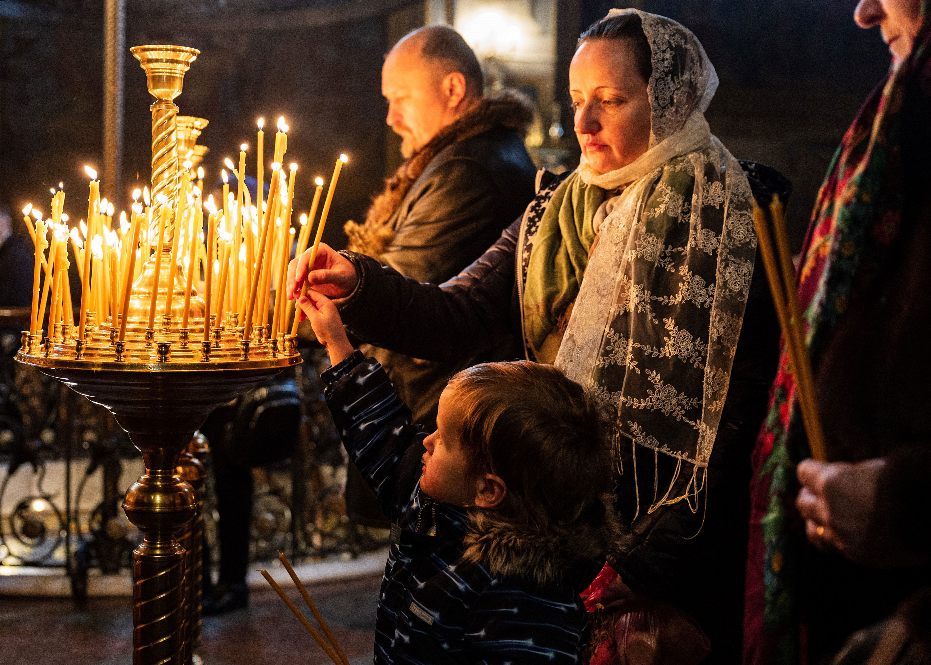 Worshippers light candles during an Orthodox Christmas service at the St. Michael's Golden-Domed Monastery in Kyiv on Saturday. 