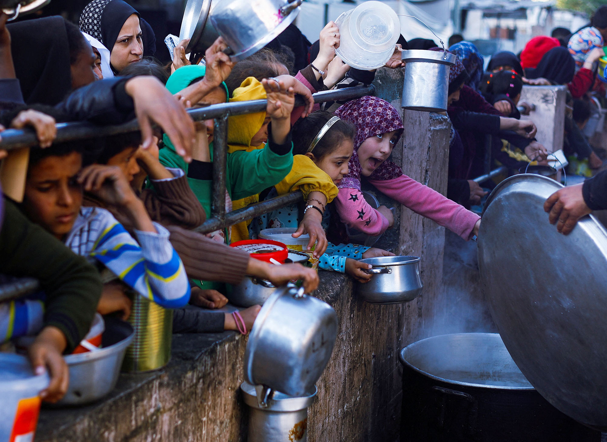 Palestinian children wait to receive food in Gaza on March 13.