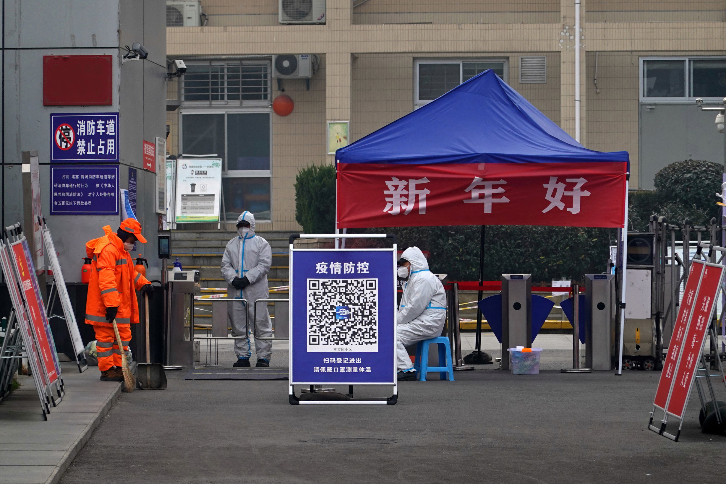 People in protective suits stand guard at an entrance of a residential compound in Xi'an on January 5.