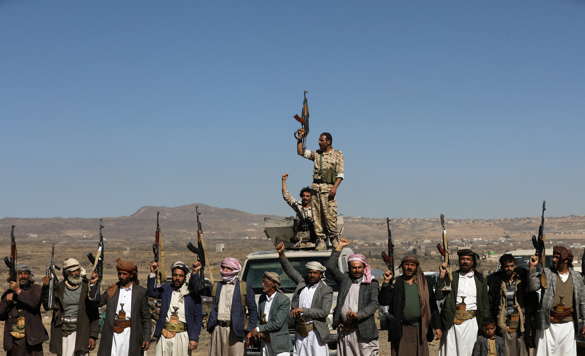 Houthi fighters and tribal supporters hold up their firearms during a protest in Yemen on Sunday.