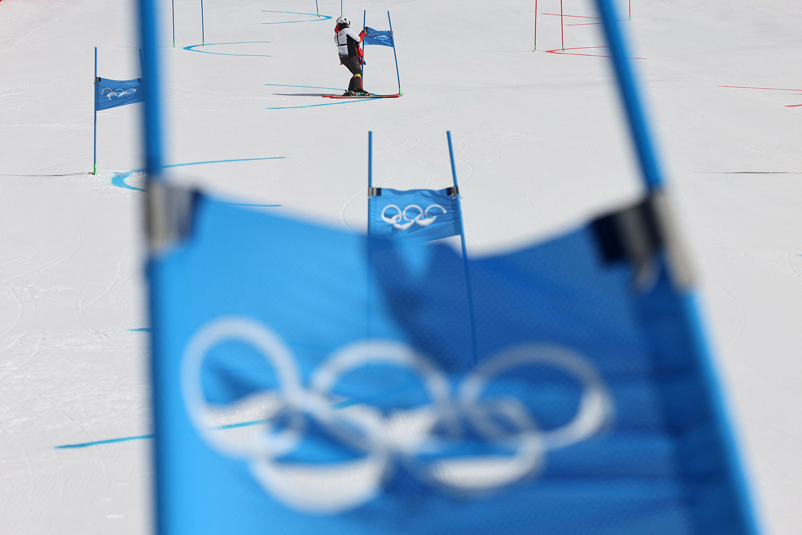 A course technician removes flags from the alpine skiing course due to strong winds on Saturday.