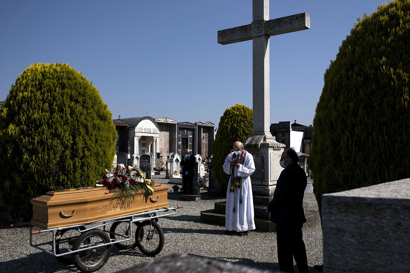 A priest conducts a funeral service for a coronavirus victim on April 24, in Cuneo, Italy.