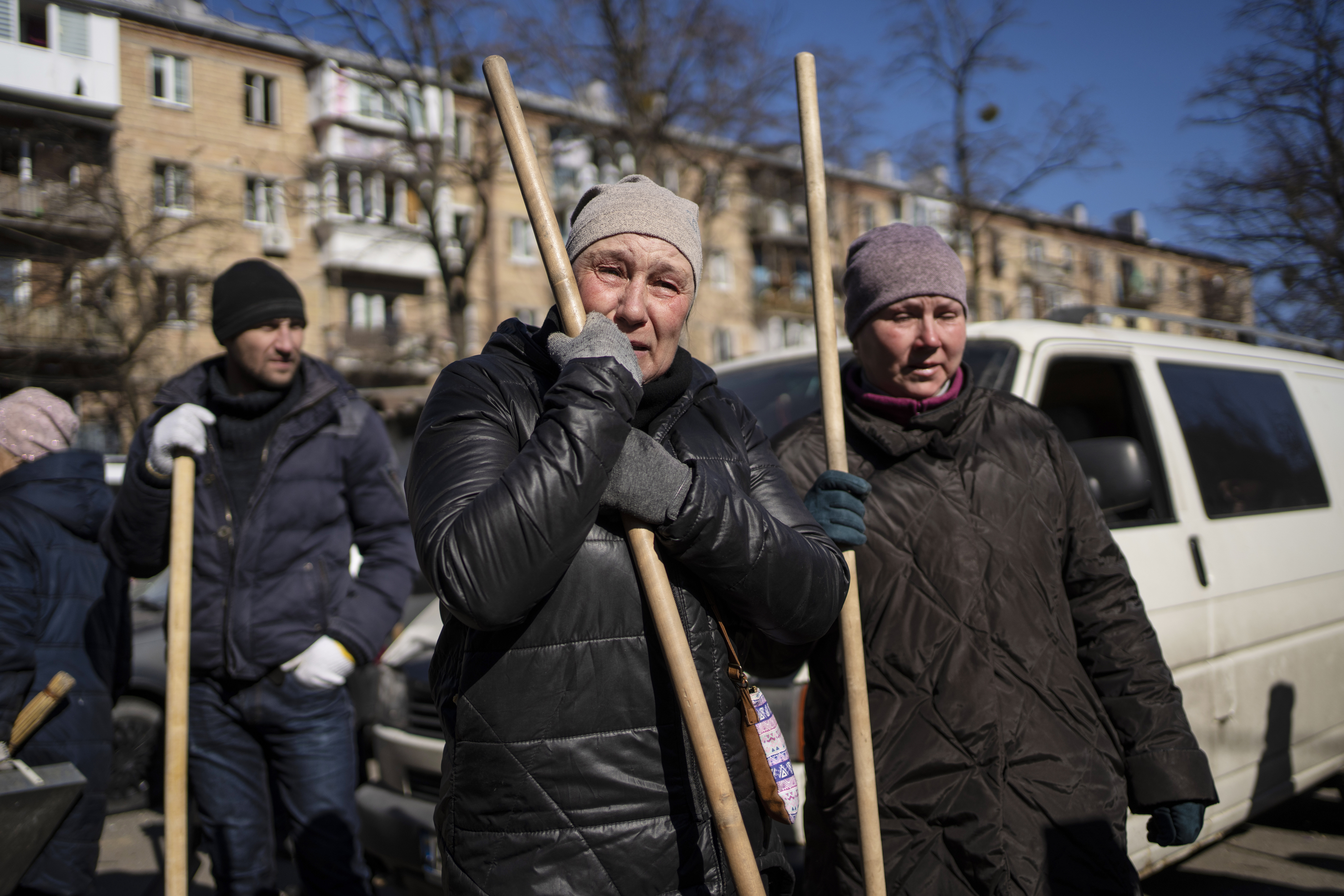 A woman cries before starting to clean the site where a bombing damaged residential buildings in Kyiv, Ukraine, on March 18.