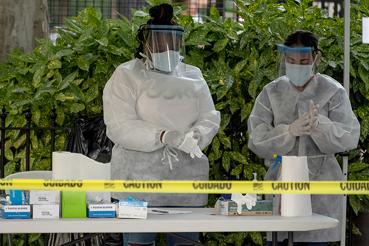 Two medical workers change their gloves at a free coronavirus testing location outside Washington Square Park on Monday, July 20. 