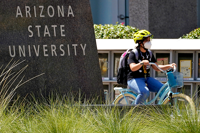 A cyclist crosses an intersection on the campus of Arizona State University on Tuesday, September 1, in Tempe, Arizona.