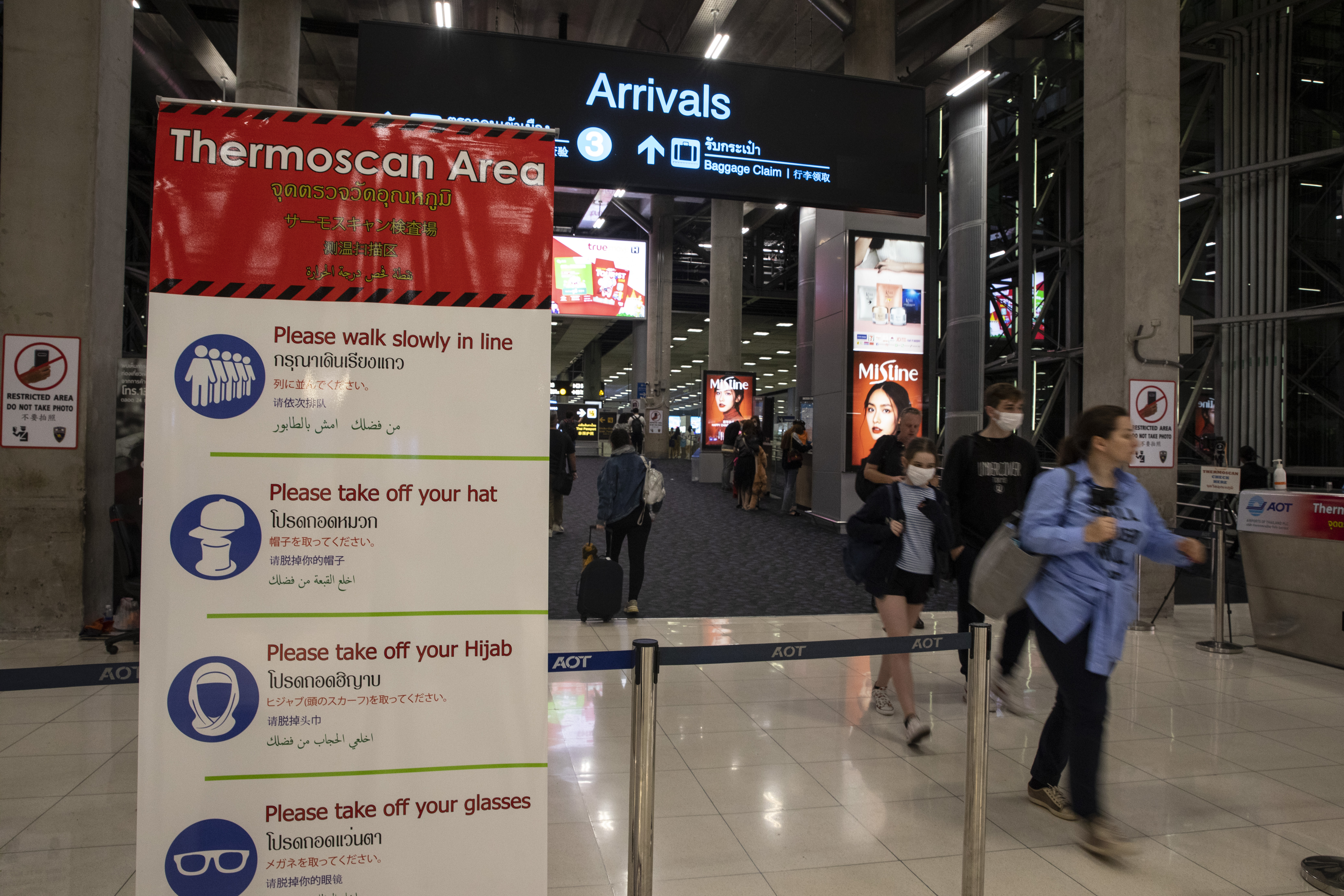 Travelers walk through a thermal scanner at Suvarnabhumi International airport in Bangkok, Thailand on February 10. 