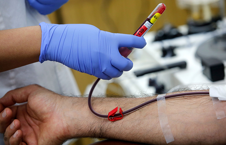 A medical worker at Magen David Adoms Blood Services collects blood samples donated by recovered novel coronavirus patients for plasma extraction, contributing to Israel's new experimental antibodies treatment, in Sheba Medical Center Hospital near Tel Aviv, on June 1.