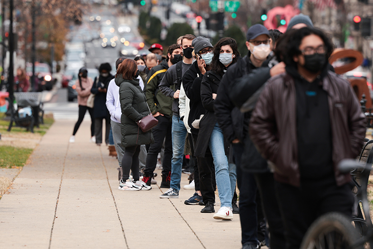 People wait in line at a testing site to receive a free COVID-19 PCR test in Farragut Square on December 28, 2021 in Washington, DC.