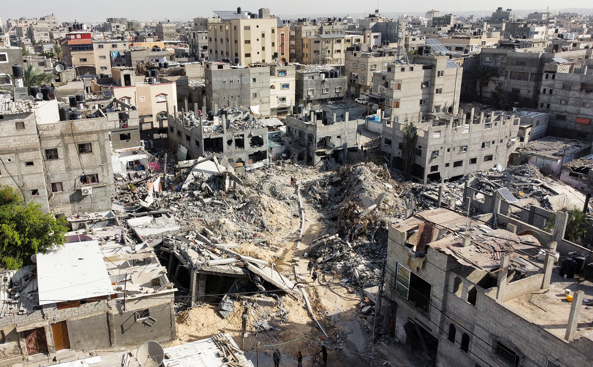 Palestinians walk among the rubble as they inspect houses destroyed by Israeli strikes, amid the temporary truce between Hamas and Israel, in Khan Younis, Gaza, on November 27.