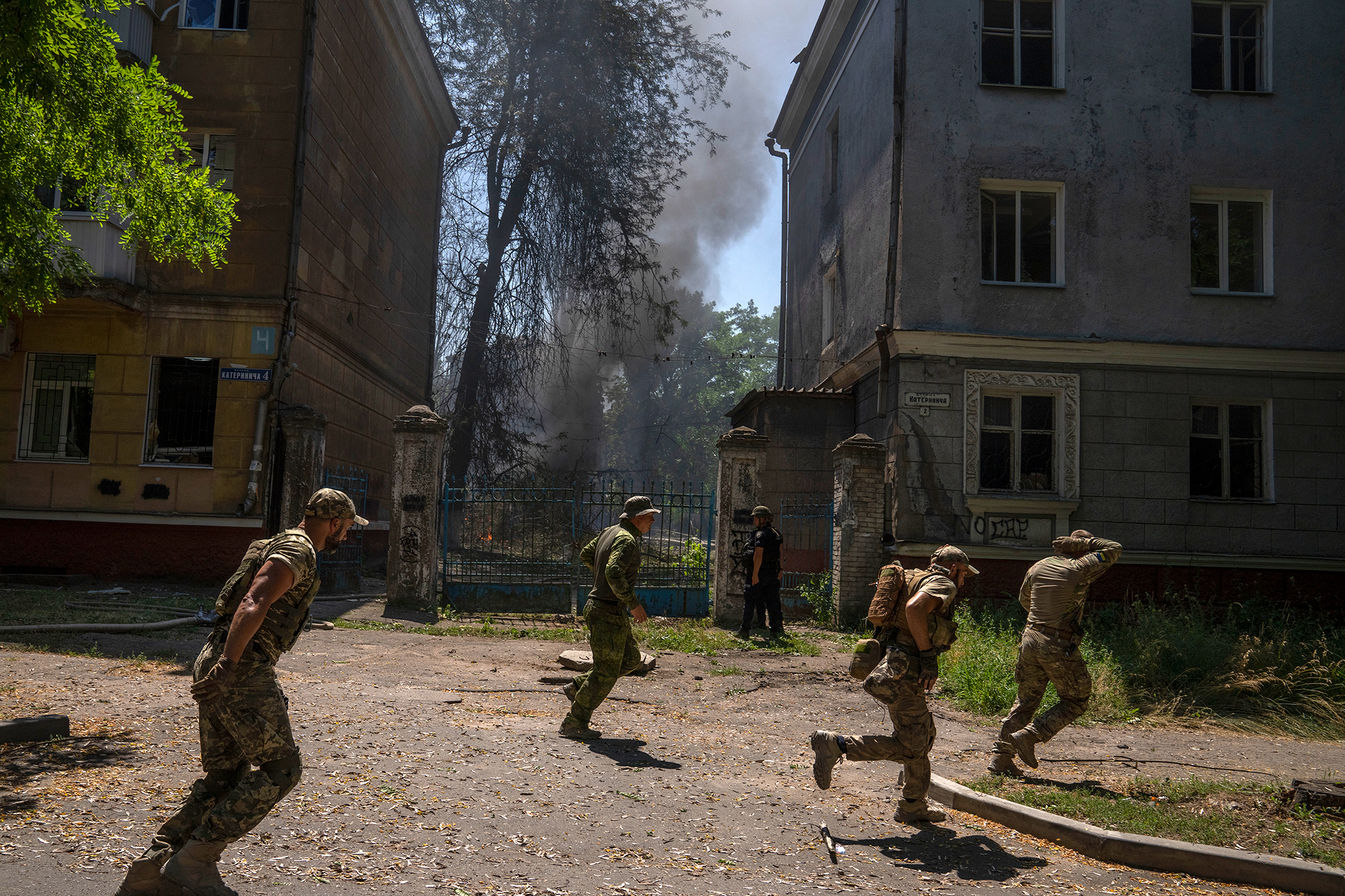 Ukrainian soldiers run after a strike hit a residential area in Kramatorsk, Ukraine, on Thursday, July 7. 
