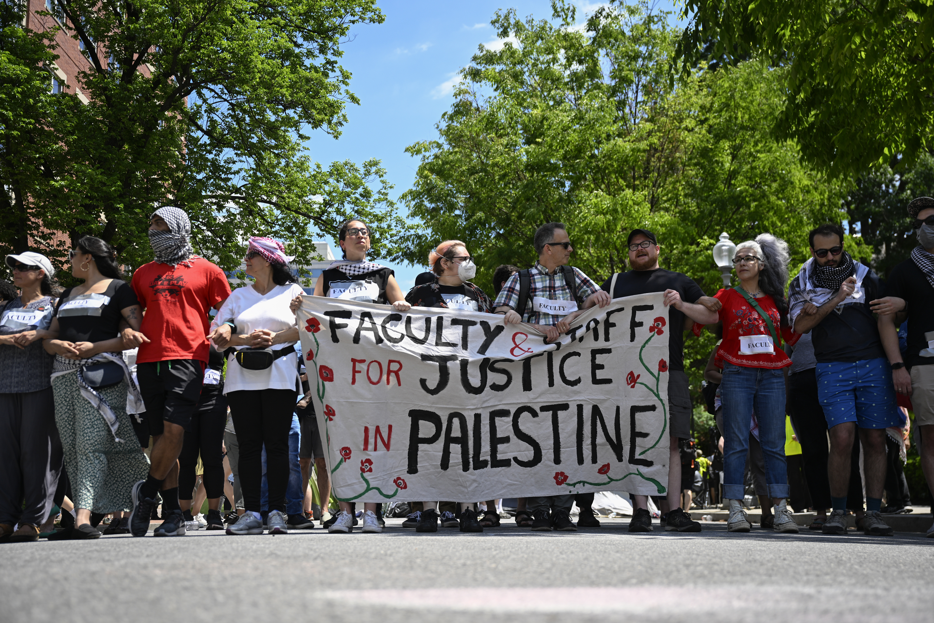 Faculty at George Washington University holds banners as they continue pro-Palestinian demonstrations at George Washington University in Washington DC, on May 2.