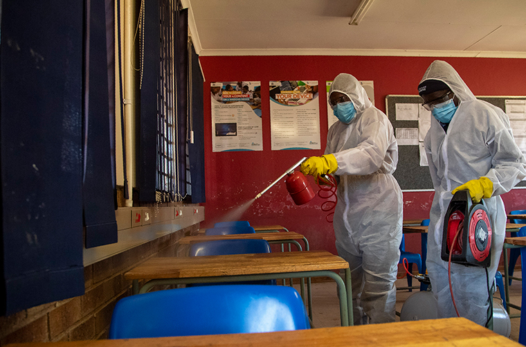 A disinfection team disinfects the classroom at Ivory Park Secondary School in Johannesburg, South Africa, Thursday, May 28, 2020, ahead of the June 1, 2020, re-opening of Grade 7 and 12 learners to school.