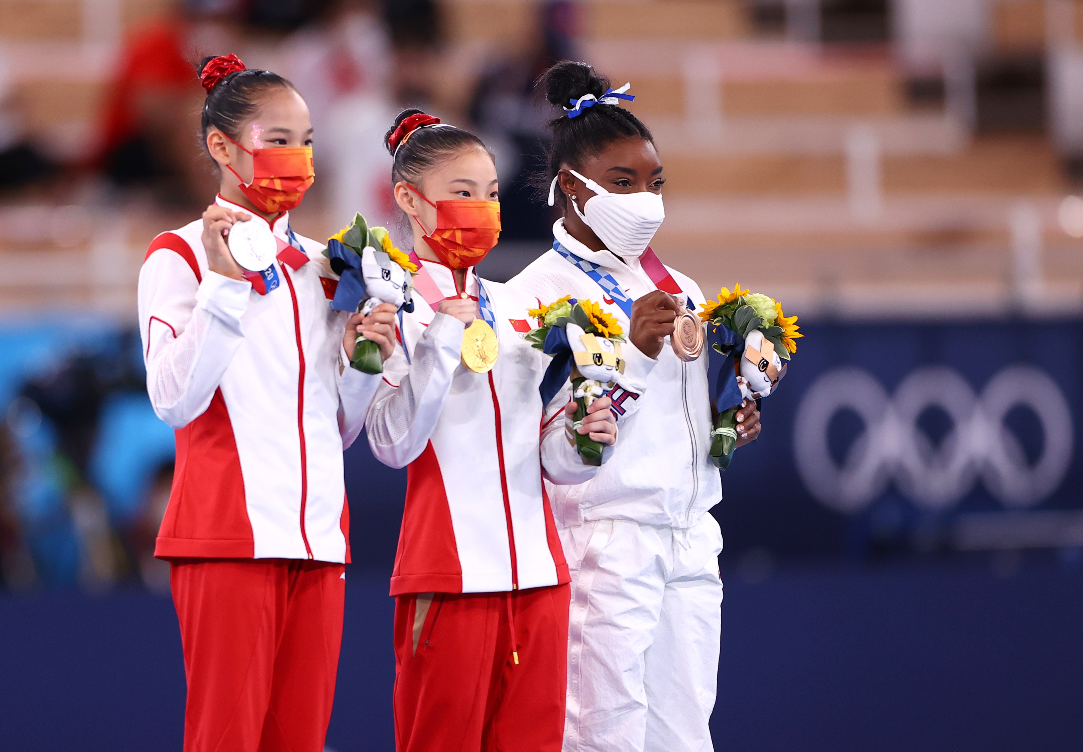 Gold medalist Guan Chenchen of China, center, celebrates on the podium with silver medalist, Tang Xijing, also of China, left, and bronze medalist Simone Biles of the United States. 