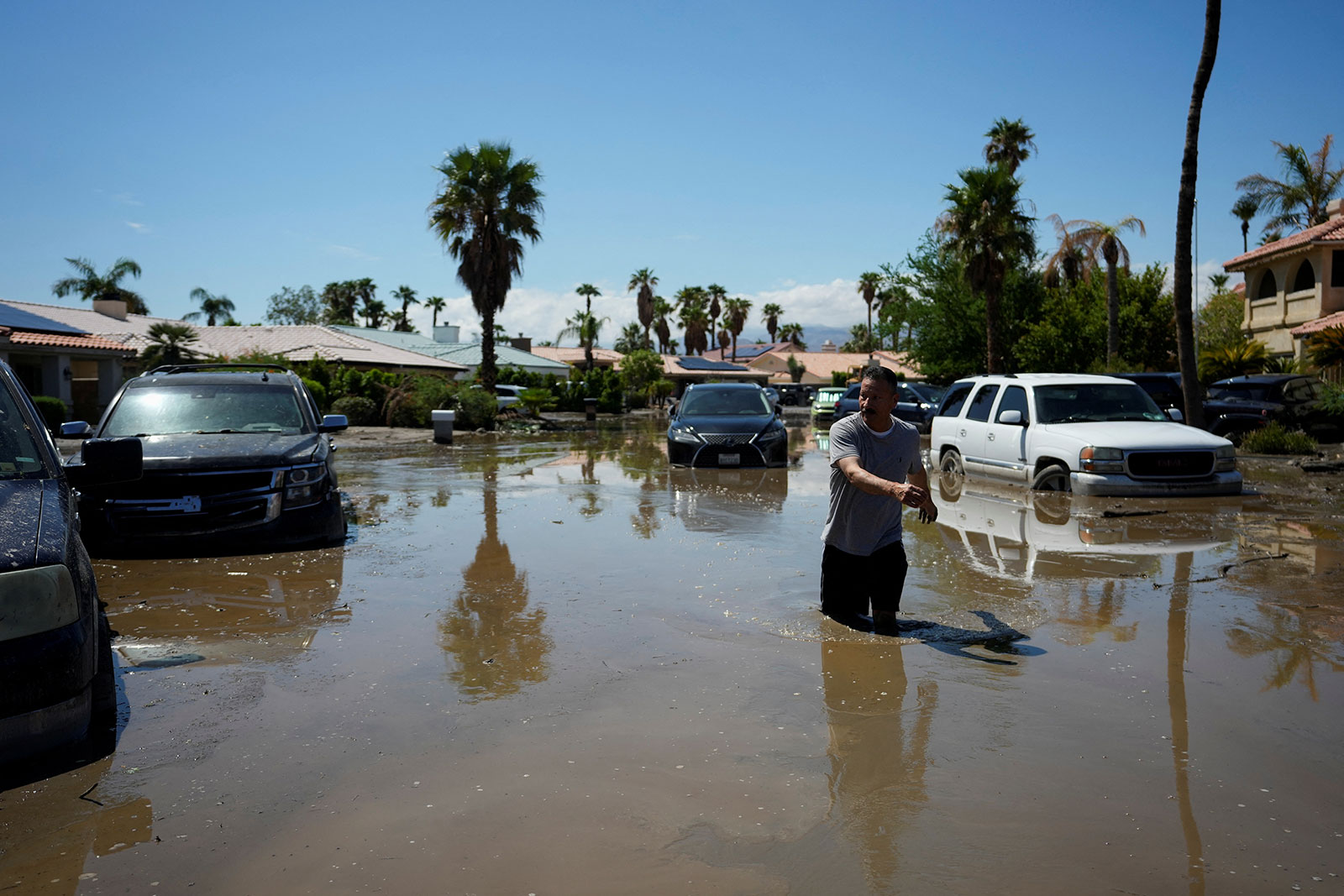 Ronald Mendiola returns to his home through a flooded street in Cathedral City, California, on Monday.