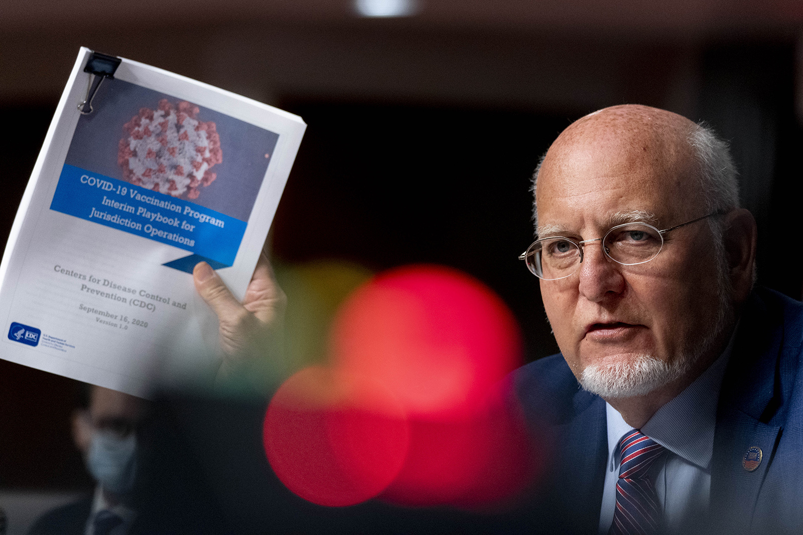 Director Dr. Robert Redfield holds up a CDC document while he speaks at a hearing of the Senate Appropriations subcommittee reviewing coronavirus response efforts on Wednesday in Washington.