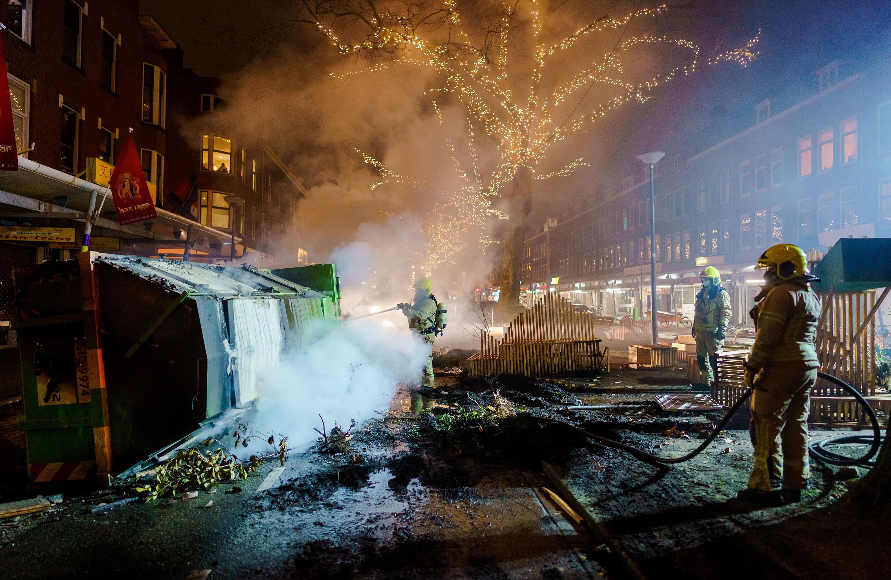 Firefighters work to extinguish a fire in Rotterdam on January 25, after a wave of riots in the Netherlands in response to a coronavirus curfew introduced over the weekend.