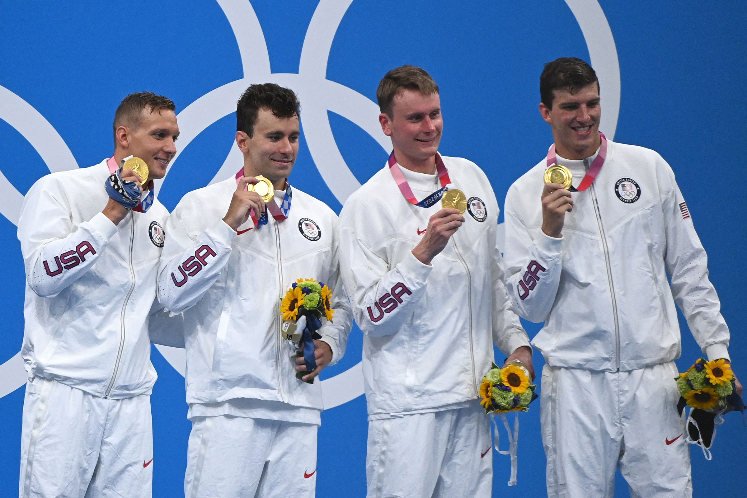 USA's Caeleb Dressel, Blake Pieroni, Bowen Becker and Zach Apple pose with their gold medals on the podium after the 4x100m freestyle relay swimming event on July 26. 