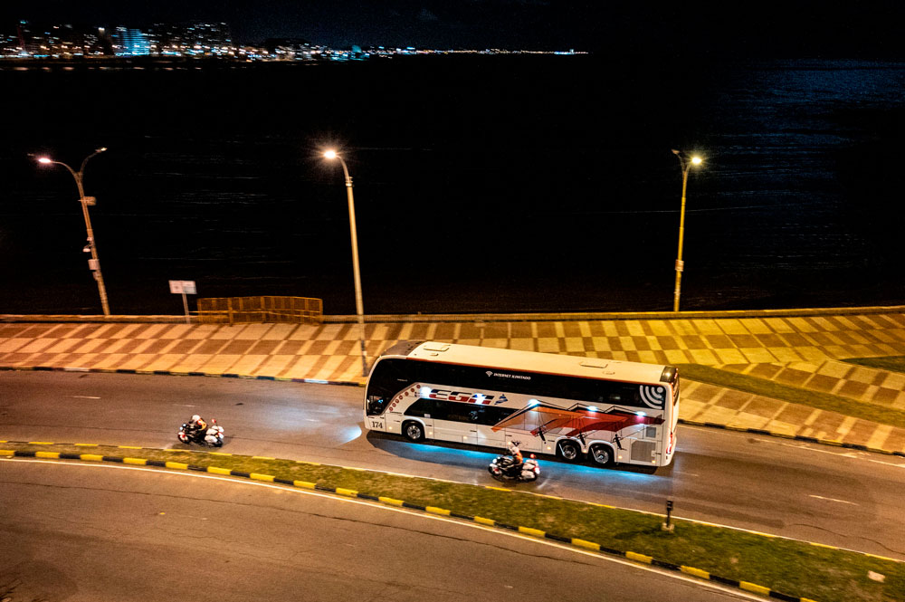 A bus carrying passengers from the coronavirus-stricken Australian liner Greg Mortimer rides along Montevideo's coastline on April 10.