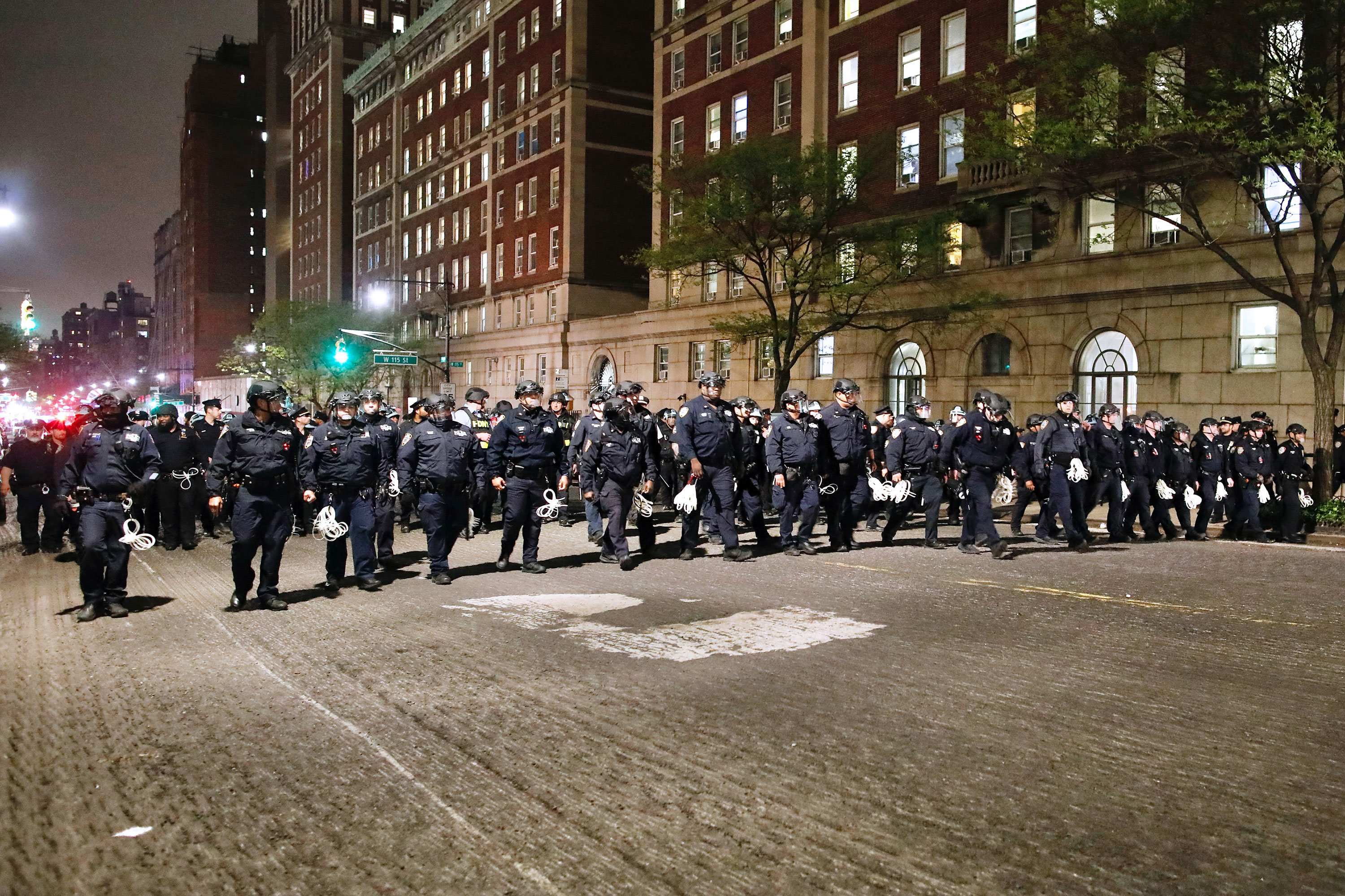 NYPD officers in riot gear march onto the Columbia University campus. 