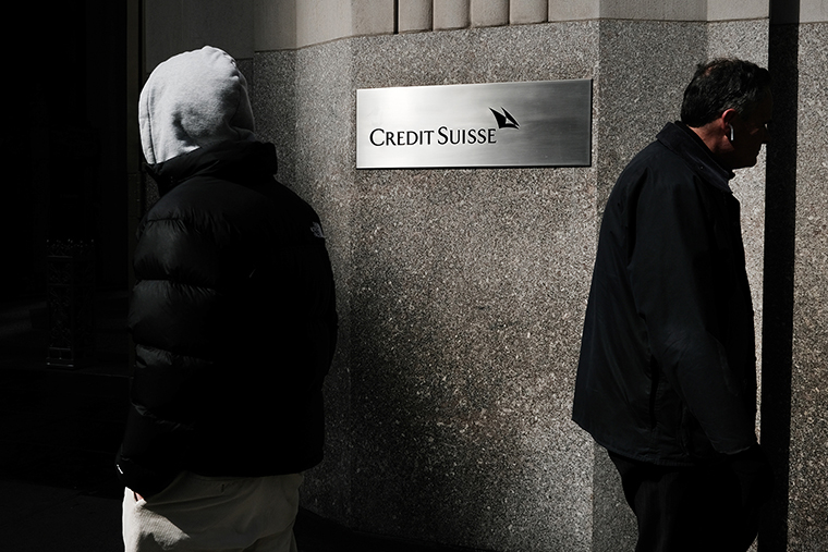 People walk by the New York headquarters of Credit Suisse on March 15 in New York City.
