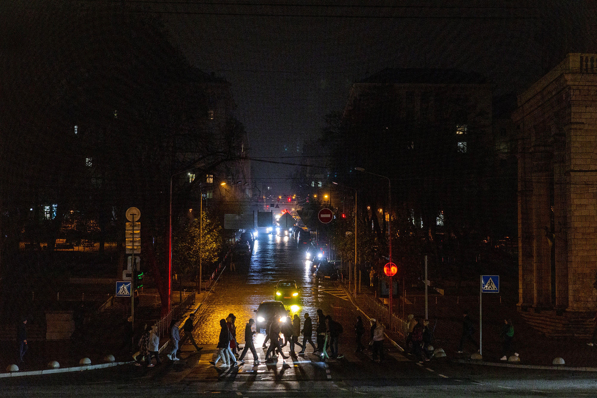 Pedestrians cross a street during a power cut in downtown Kyiv, Ukraine, on November 10.