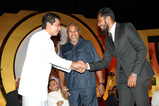 A photo posted in 2016 on the Sri Lankan Minister of Science Technology and Research’s official Facebook page from a 2016 event shows Sujeewa Senasinghe (in white), former State Minister of International Trade, shaking the hand of Imsath Ahmed Ibrahim (right) as his father (middle), billionaire spice trader Mohamed Ibrahim, looks on.