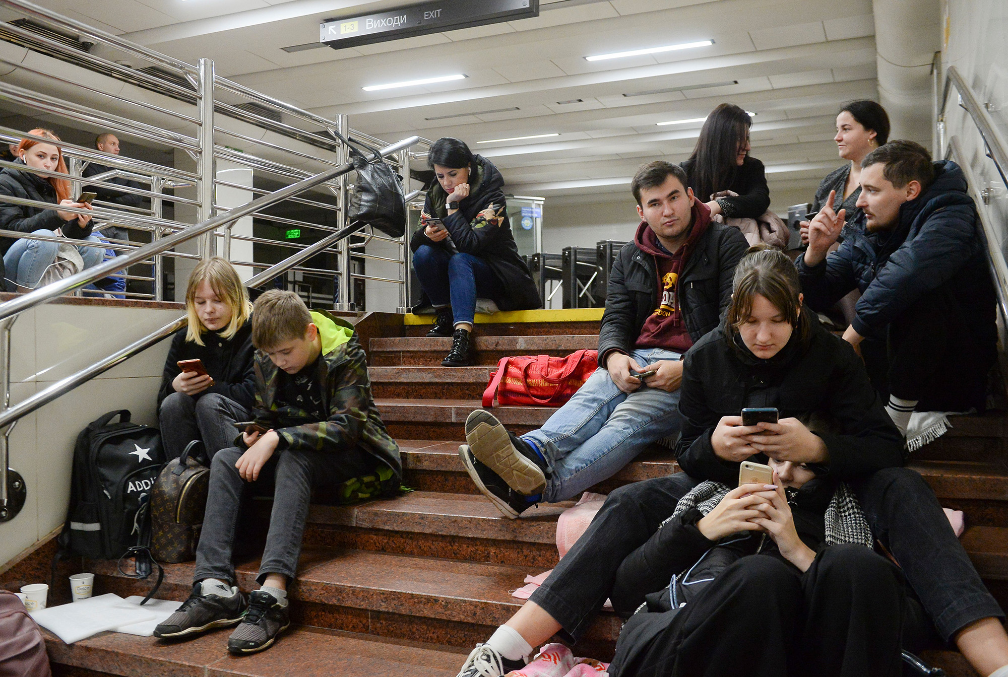 People check their phones as they shelter inside a metro station during shelling in Kyiv, Ukraine, on October 31.