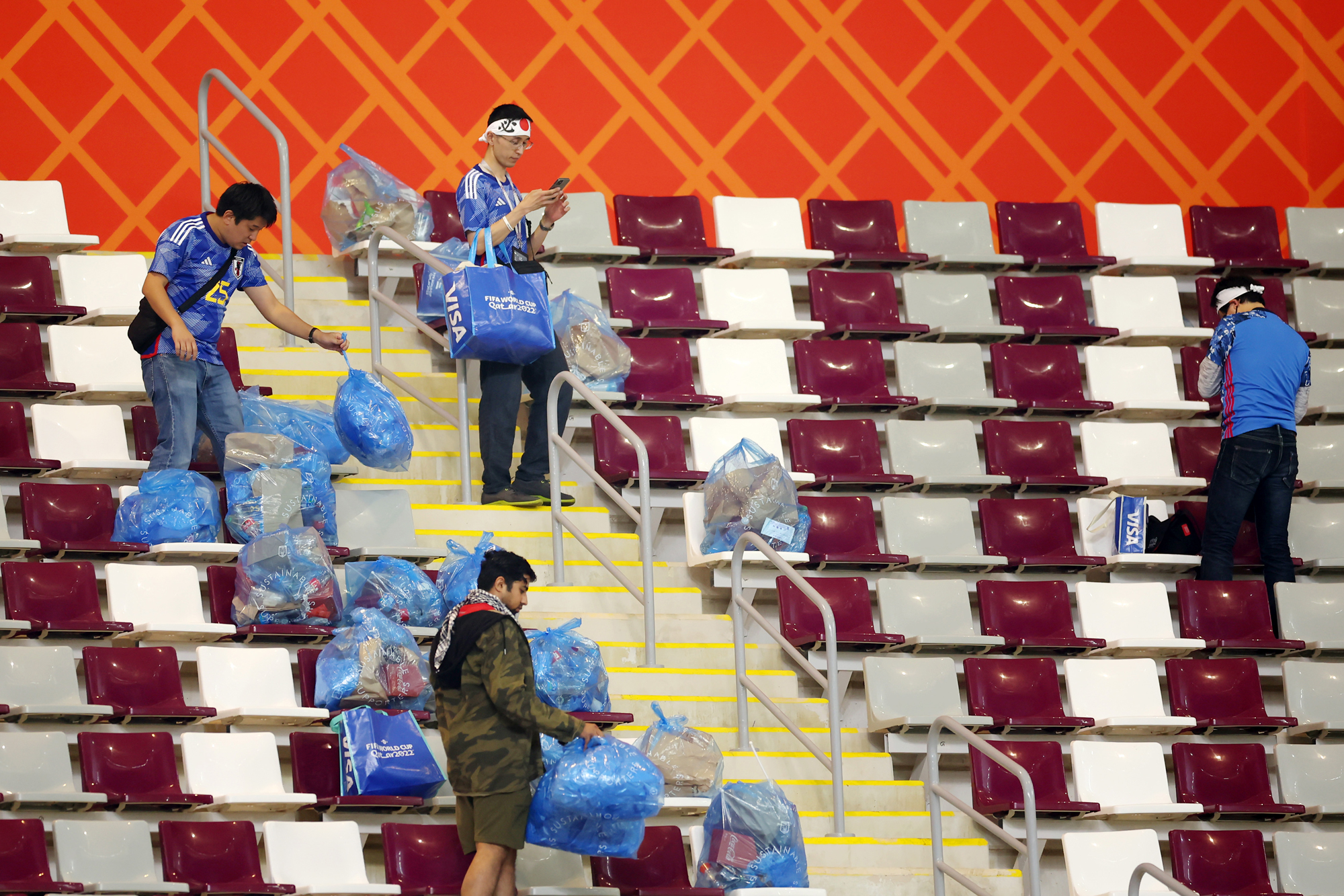 Japanese fans clear garbage from the stands after the Germany and Japan match at Khalifa International Stadium in Doha, Qatar on Wednesday. 