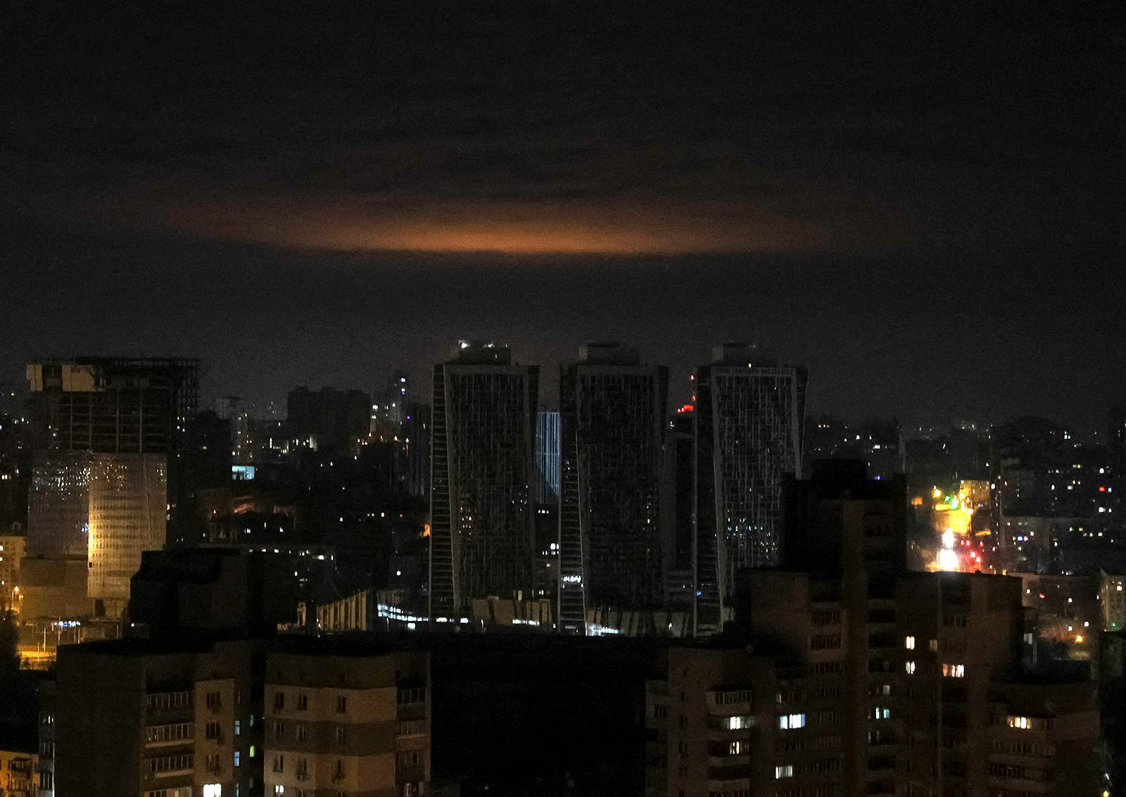 A glow from explosion is seen over the city's skyline during a Russian drones strike in Kyiv on January 1.