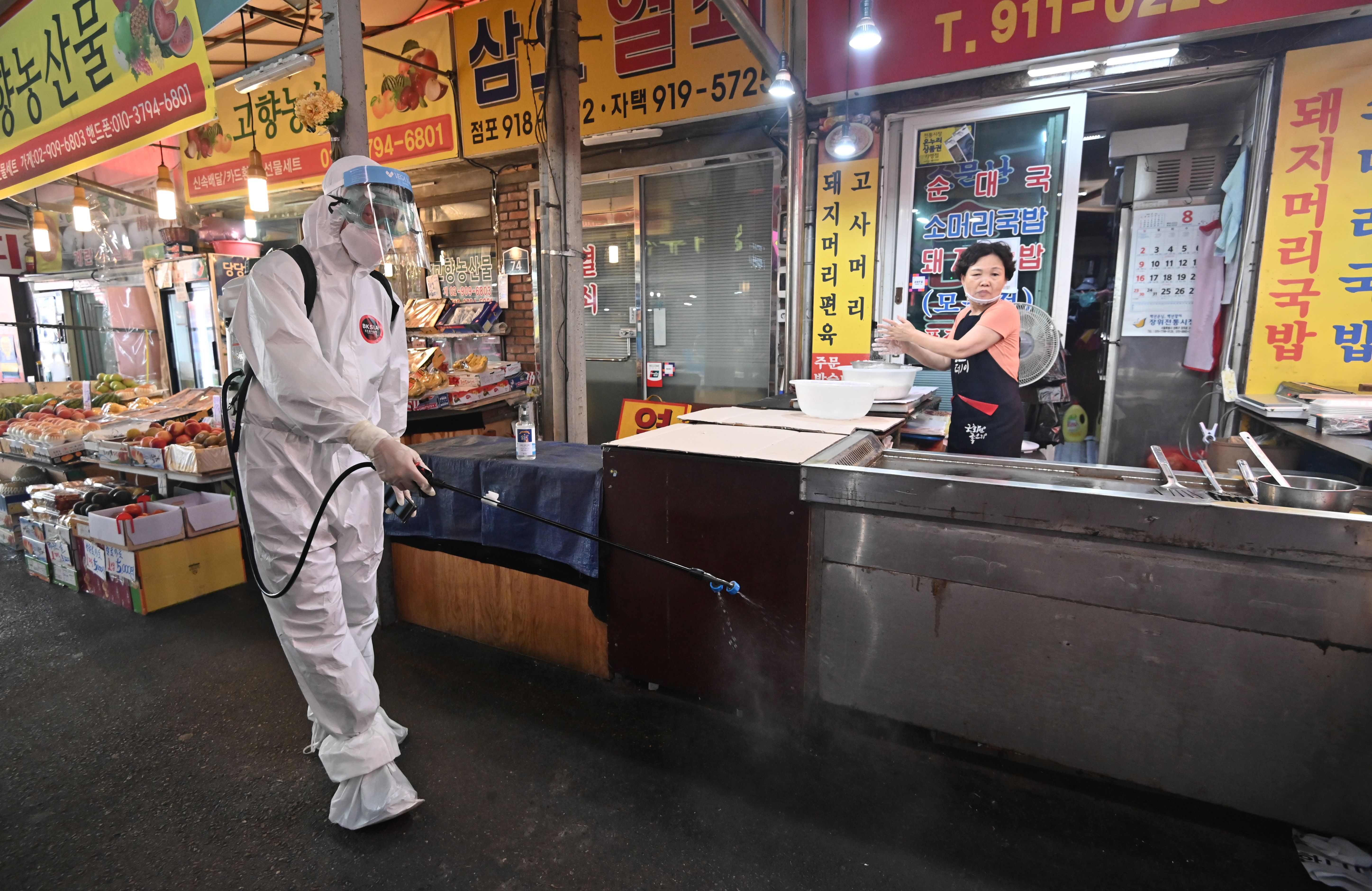 A health worker sprays disinfectant at a market near the Sarang Jeil Church, a new coronavirus infection cluster, in Seoul on August 18. 