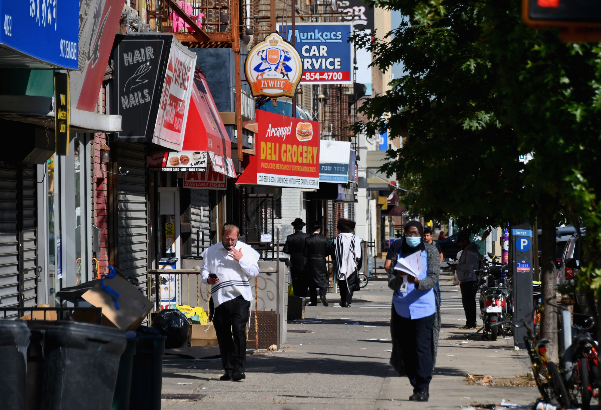People walk past closed stores in the Borough Park section of Brooklyn, New York City, on October 9.