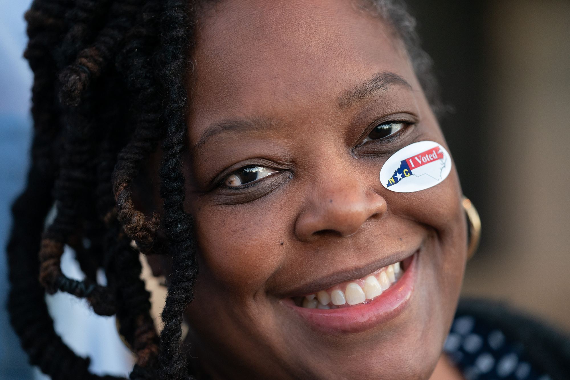 Lakeisha Hill smiles after putting a voting sticker on her face in Winston Salem, North Carolina, on Tuesday.